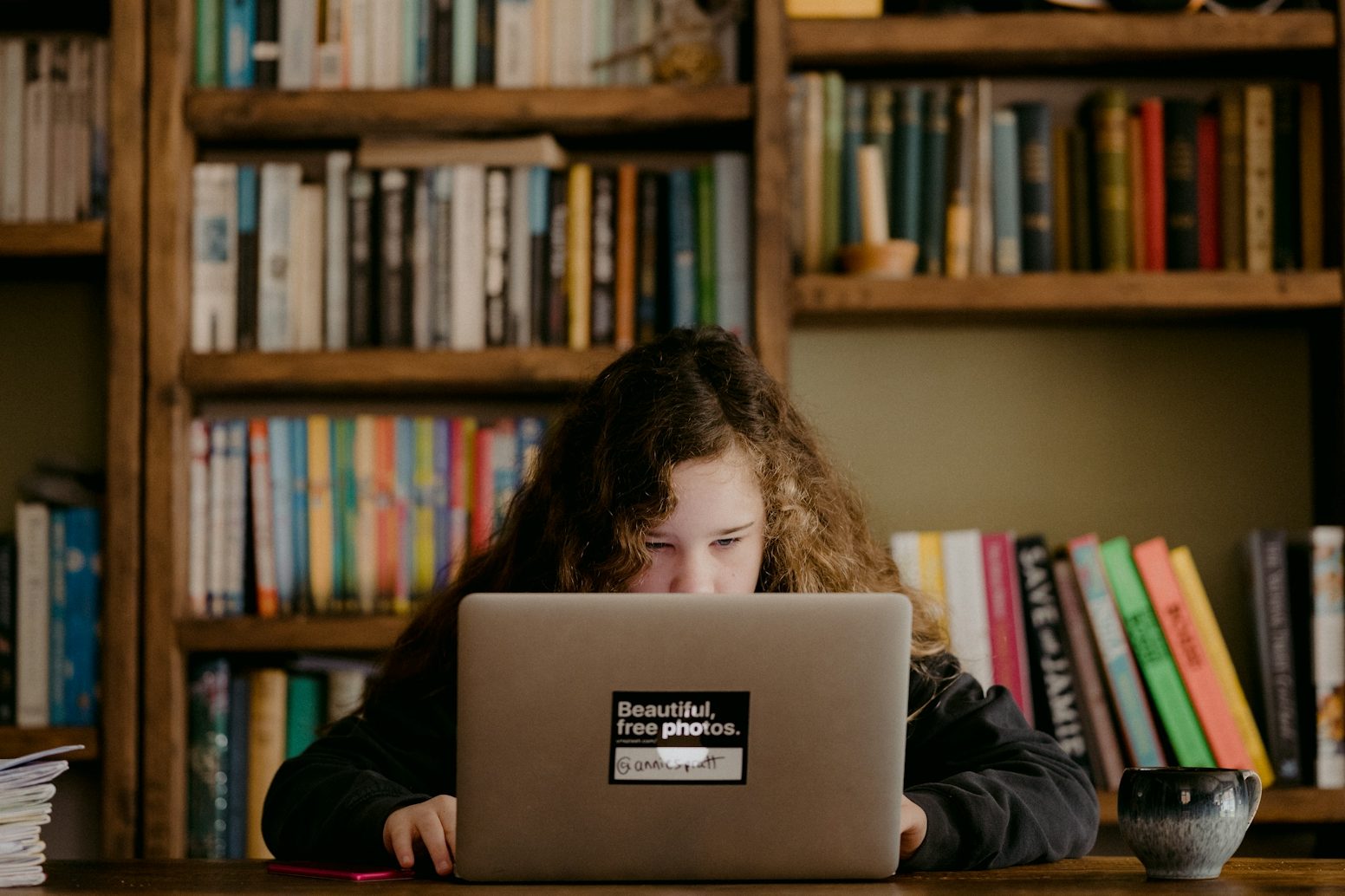 Jong meisje Middelbare scholier gebruikt studiekeuze platform voor studiekeuze op laptop